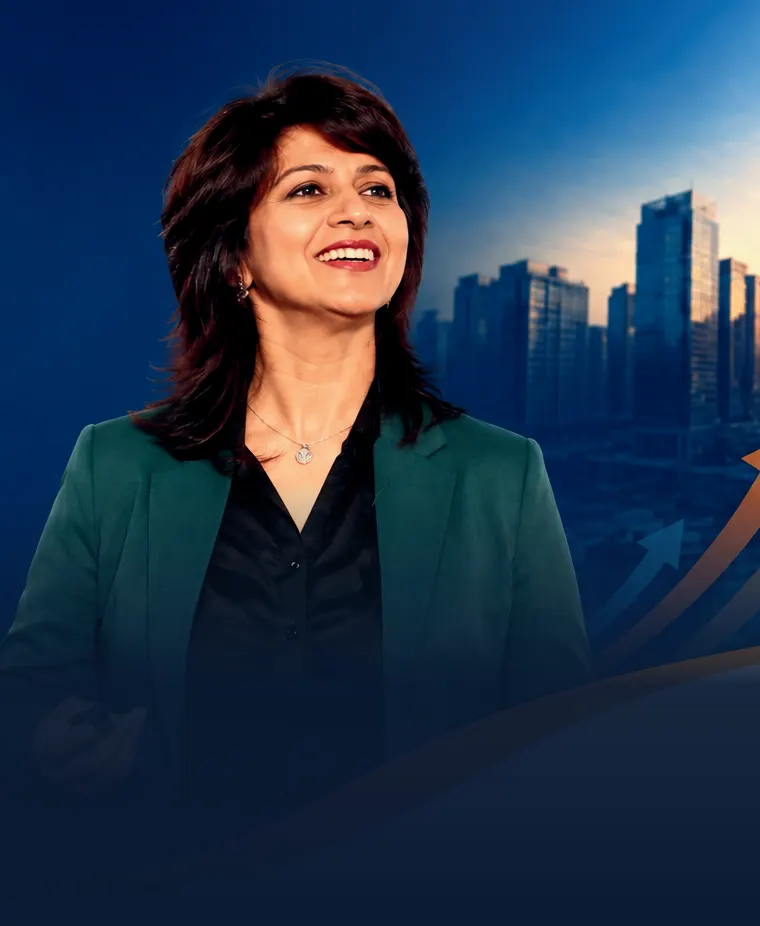 Anshul Verma, business coach, smiling on stage in front of a city skyline